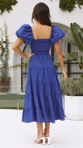 Detail view of royal blue puff sleeve dress showing smocked open back and tiered skirt