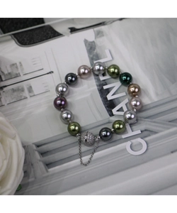 Détail d'un bracelet en perles multicolores avec fermoir magnétique scintillant et chaîne