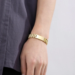 Close-up of gold stainless steel ID bracelet with rectangular plate on model wrist
