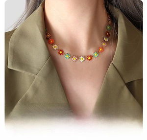 Detail of 18k gold plated titanium steel necklace with colorful daisy flower pendants