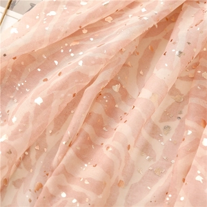 Macro detail of soft pink scarf with metallic gold foil abstract zebra pattern and fringe