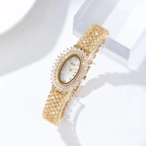 Close-up of golden oval watch with sparkling crystals and mother of pearl dial