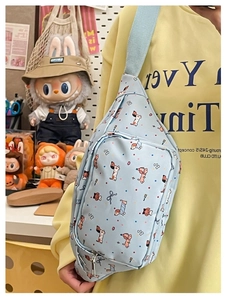 Detail view of light blue crossbody bag with cartoon dachshund pattern and strap