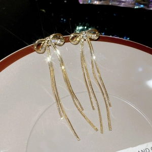 Detail von eleganten Gold-Schleifen-Ohrringen mit Zirkon-Fransen und langen Metall-Quasten