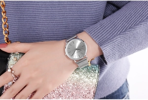Close-up of Hannah Martin silver watch with round dial and mesh strap on female wrist
