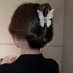 Close-up of golden butterfly hair claw clip encrusted with sparkling cubic zirconia crystals