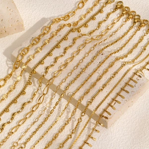 Minimalist gold stainless steel chain bracelets displayed on elegant beige stone surface