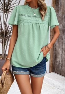 Detail of light green short sleeve top with lace patchwork and 3D polka dot texture
