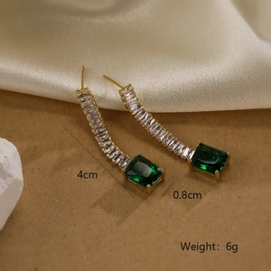 Detail view showing 4cm gold-plated tassel earrings with green gems and zircons