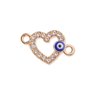 Macro view of rose gold heart charm connector with white crystals and blue evil eye detail