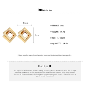 Detail showing golden geometric hollow earrings with iron material and silver needles