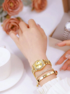 Close-up of gold watch with crystals and matching screw-motif bracelet on wrist