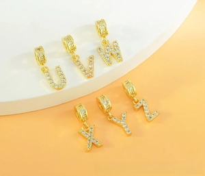 Close-up of gold-plated U to Z letter pendants with sparkling cubic zirconia inlay