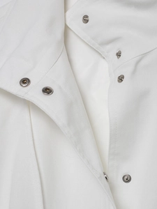 Close-up of white linen bomber jacket with silver metal snap buttons and collar detail