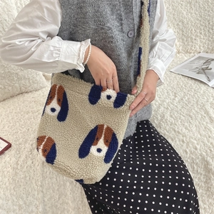 Close-up detail of plush lamb wool bucket bag with cute cartoon dog pattern and soft texture