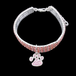 Detailed view of three-row rhinestone pet collar with pink paw print charm and silver base