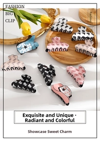 Detail of big hair clips with heart and star patterns on a wooden tray with tulips