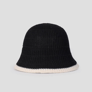 Detail of summer knit bucket hat featuring black texture and cream contrast trim edge