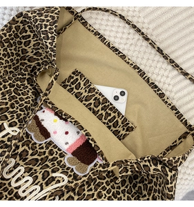 Detail view of leopard print tote bag interior showing functional pocket and large capacity