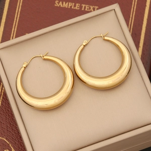 Detailed close-up of chunky gold geometric earrings on a velvet jewelry stand