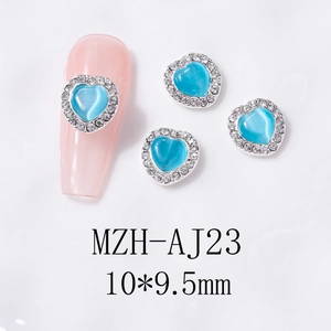 Macro view of blue cat-eye heart nail charm with silver crystal border, 10x9.5mm size