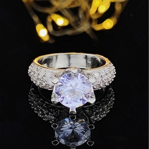 Macro shot of silver ring featuring six-prong lavender stone and micro-pavé band