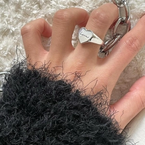 Close-up of 925 sterling silver heart-shaped signet ring with Love script engraving