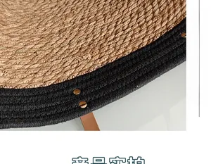 Macro detail of natural straw tote bag with black braided trim and gold metal rivets
