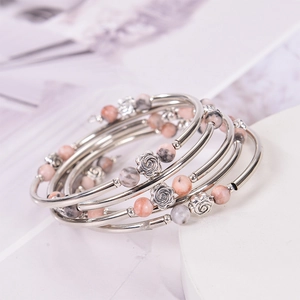 Détail du bracelet multi-rangs en pierre zébrée avec breloque rose et tubes métalliques