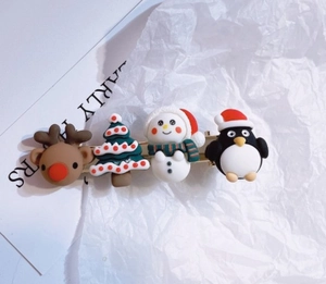 Detail view of festive resin hair clips featuring Santa, reindeer, and Christmas tree