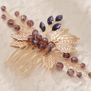 Pettine per capelli da sposa dorato con cristalli viola e foglie su sfondo beige