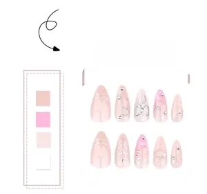 Detail of 3D bow and heart press-on nails in pink almond shape with silver accents