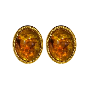 Vintage oval amber resin stud earrings with twisted gold metal border on white background