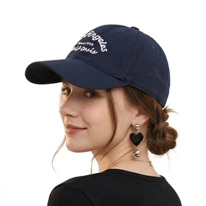 Classic navy cotton baseball cap with vintage white embroidery shown on a model