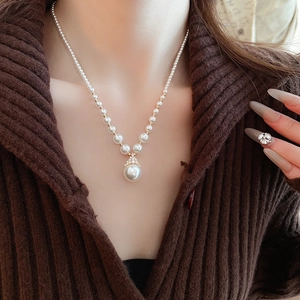 Gros plan d'un collier plaqué or avec perles dégradées et un pendentif goutte d'eau