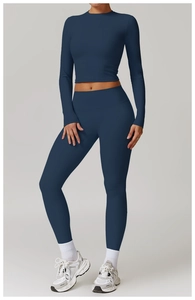 Détail d'un ensemble de yoga bleu foncé avec haut court à manches longues et legging
