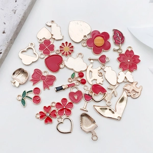 Detailansicht der roten Emaille-DIY-Anhänger mit Herz-, Kirsch- und Blumenmotiven