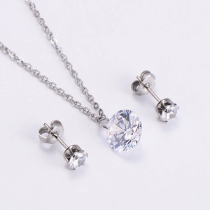 Close-up of sparkling round zircon necklace and stud earrings set in silver finish