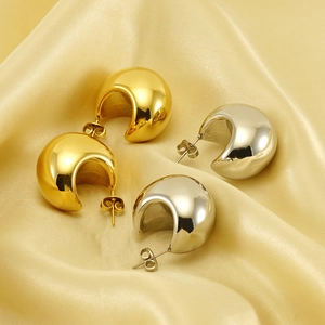 Puffy teardrop earrings in gold and silver finish displayed on elegant silk background