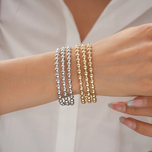 Set di 6 braccialetti con perline geometriche in finitura oro e argento lucido