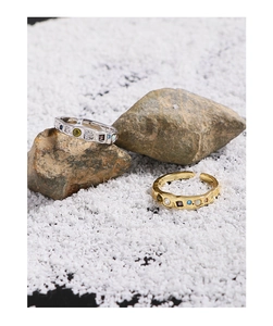 Detail of silver and gold textured rings with colorful cubic zirconia on natural stones