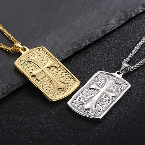 Detail of gold and silver cross square pendants with hammer texture on dark slate