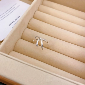 Detailed close-up of a silver bow open ring with a small zircon in a jewelry box