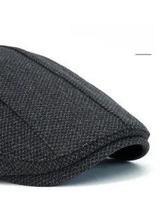 Macro detail of dark grey newsboy cap showing the bendable brim and twill texture