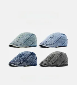 Detail of four washed denim berets in light blue, dark blue and grey with letter embroidery
