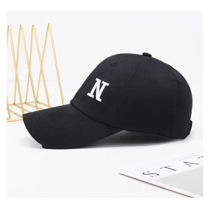 Detail of a black cotton baseball cap with white letter N embroidery on a minimal background