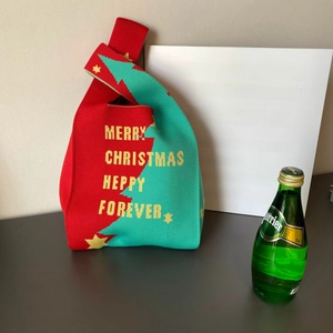 Détail d'un sac à main en tricot de Noël avec motif de sapin et texte de vœux