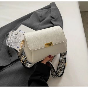 Détail de la texture en cuir litchi blanc et du fermoir en métal doré du sac carré rétro