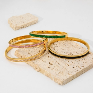 Close-up of four 18k gold plated stainless steel bangles with colorful zircon stones