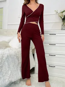 Detail of dark red two-piece lounge set featuring white lettuce edge trim and V-neck top